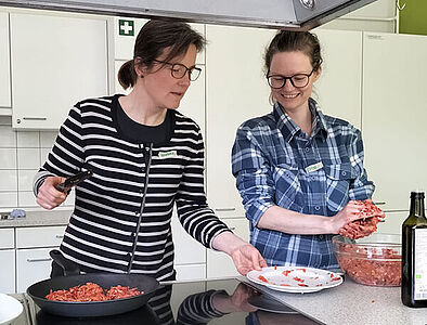 Eltern zwei Frauen bereiten vegane Bratlinge am Fabiherd zu und haben Spaß