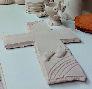 getöpfertes Kreuz mit Babyfüßen