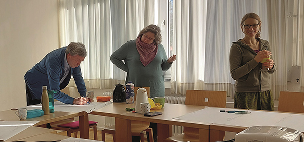 drei Erwachsene in einer Teamarbeit im Seminarraum der Fabi